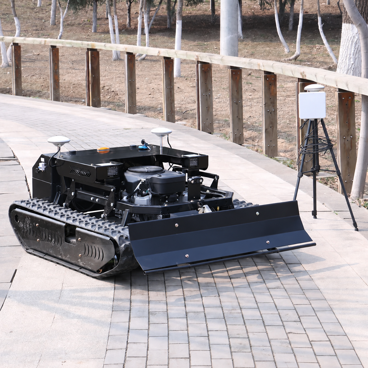 Black remote controlled crawler mower displayed outdoors